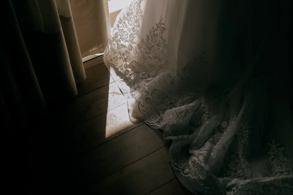 Close-up of delicate lace-like viscose or rayon fabric draped by sunlight at a window.
