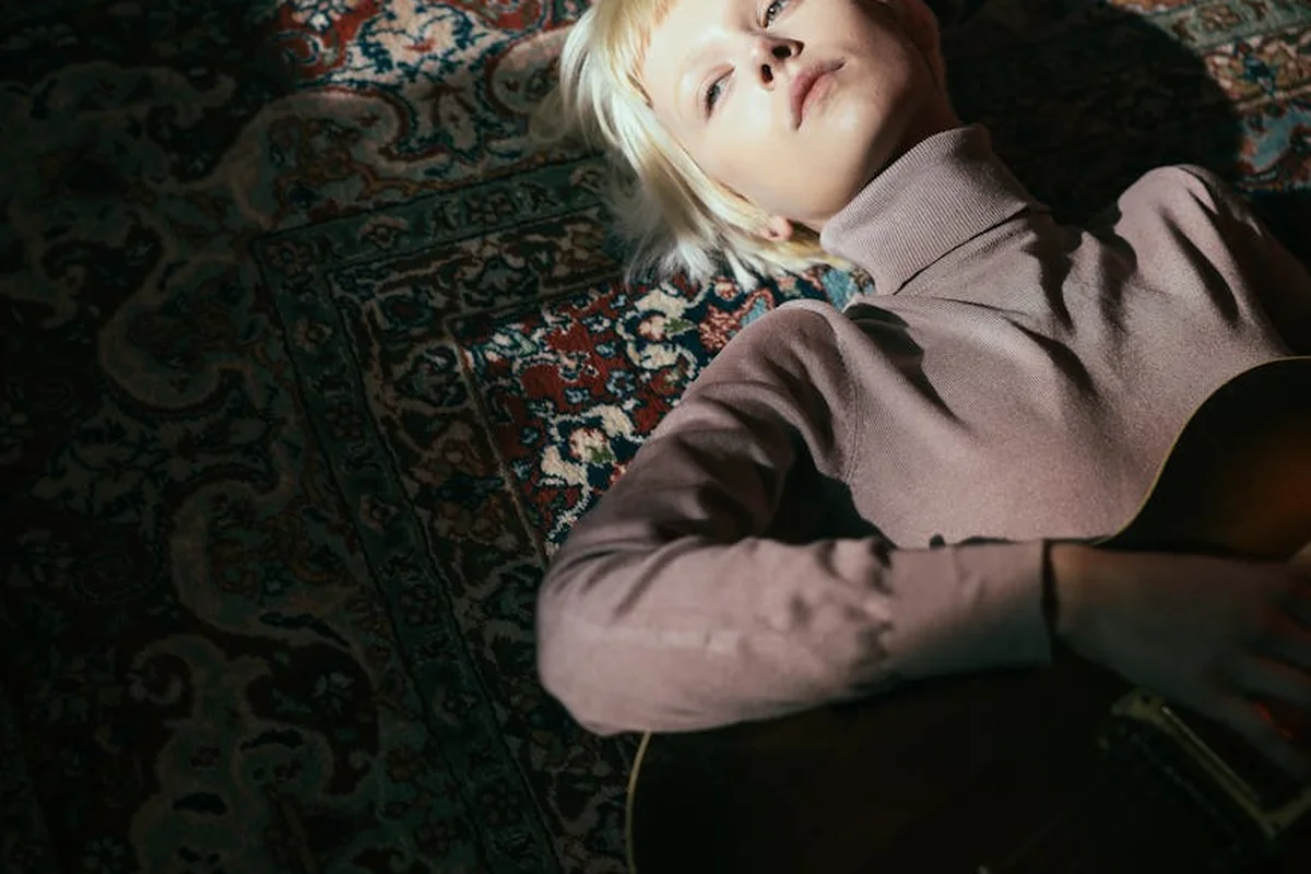 Adult person lying on a richly patterned rug, highlighting the rug's texture and weave
