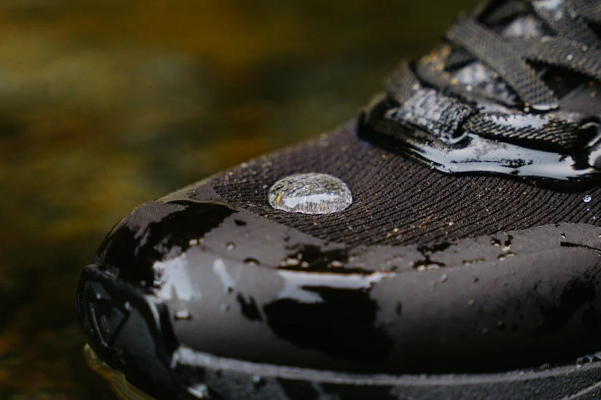 Close-up of a waterproof boot with water droplets beading on the fabric